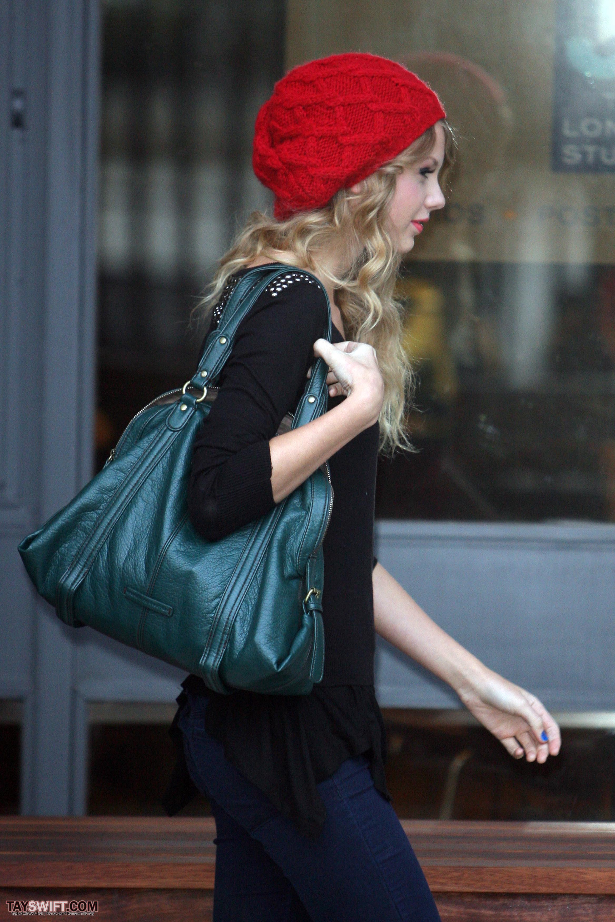 Arriving 18. Тейлор Свифт с сумкой. Тейлор Свифт в шапке. Тейлор Свифт с черной сумкой. Taylor Swift идёт с сумкой.
